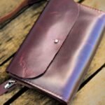Detalhe superior da bolsa Verona em couro pinhão gold exibindo a textura natural do material e a alça removível.