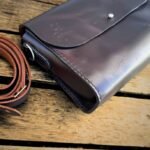 Bolsa transversal Verona Caribu em couro legítimo café com fechamento em pino metálico prateado.
