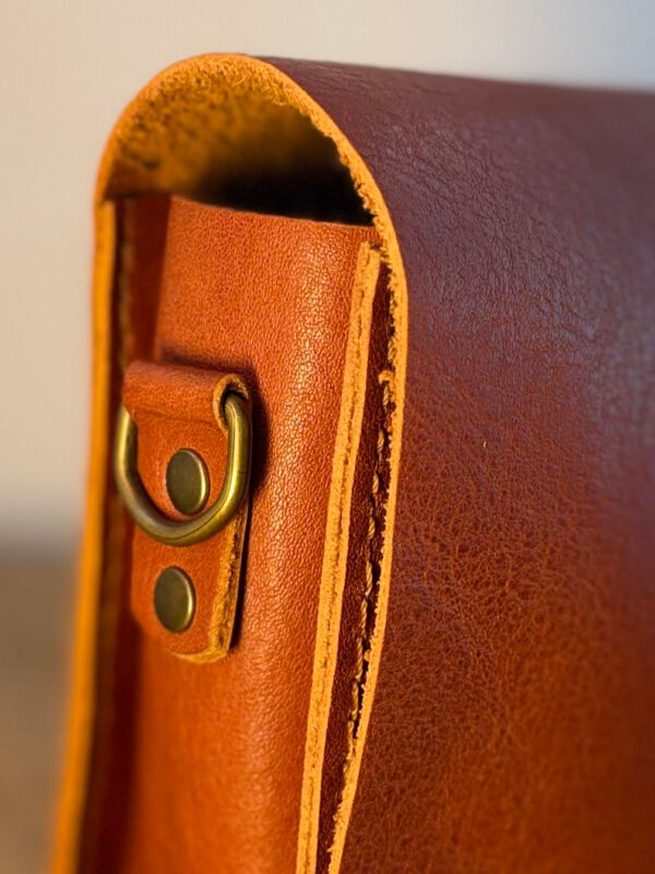 etalhe da costura e metais em latão da bolsa Parruá em couro legítimo